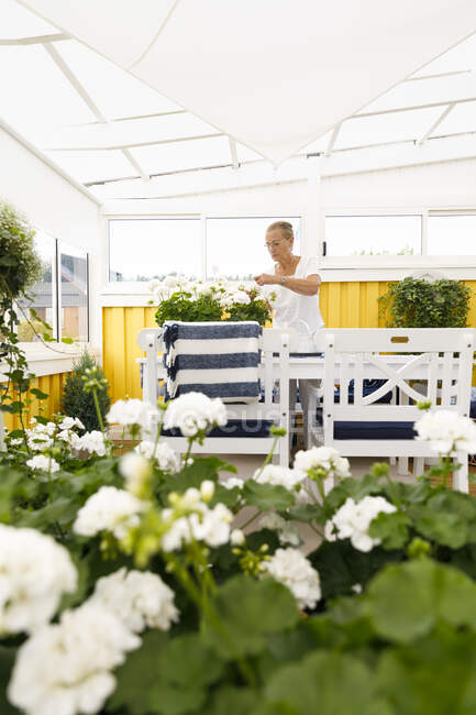 Senior woman gardening with white plants — Fotografia de Stock