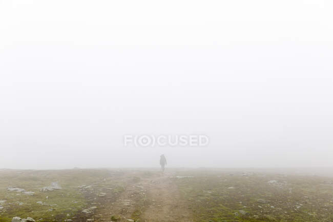 Donna con zaino trekking nella nebbia — Foto stock