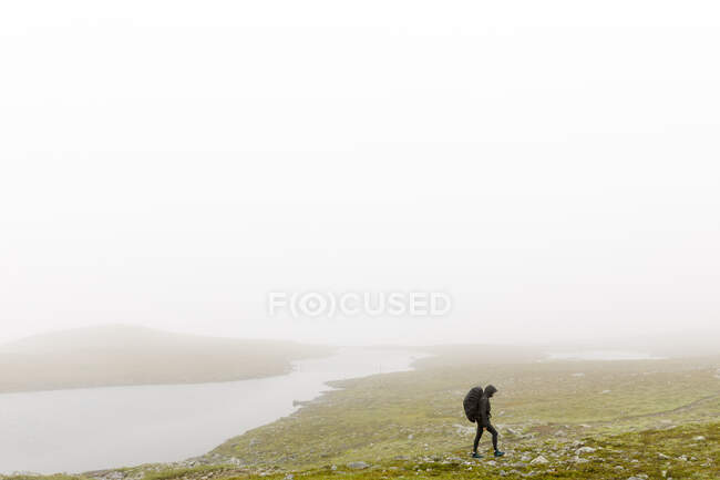 Woman with backpack hiking in fog — Stock Photo