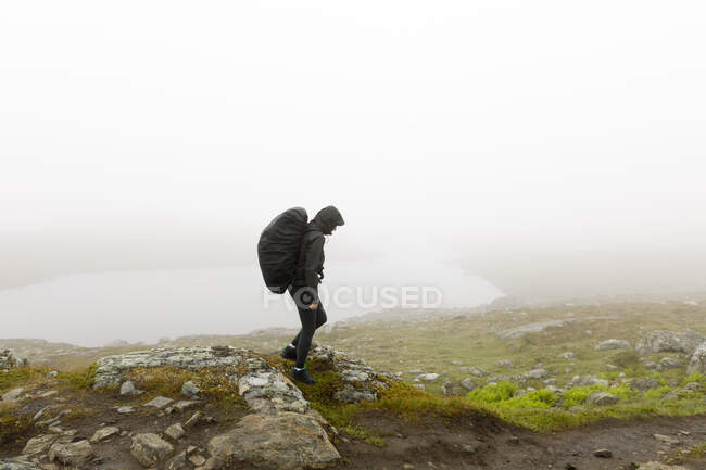 Woman with backpack hiking in fog — Stockfoto