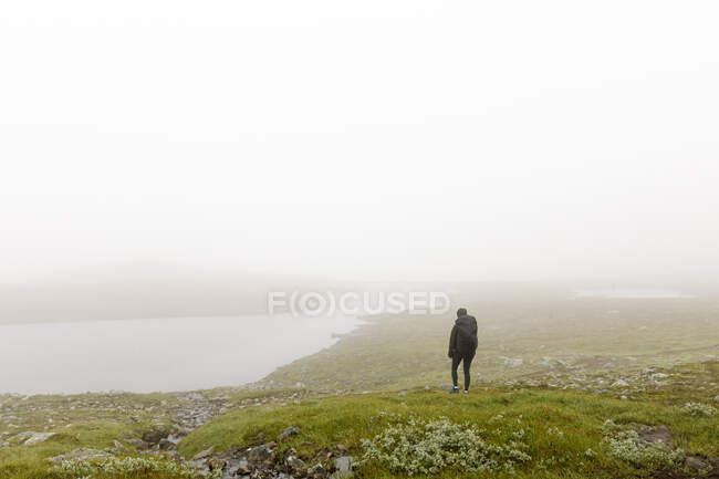 Femme avec backpac randonnée dans le brouillard — Photo de stock