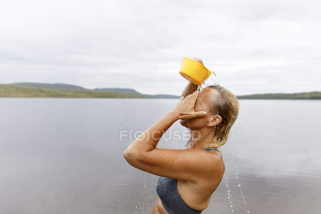 Woman bathing with water from lake — Stockfoto