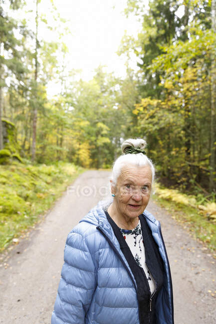 Senior woman on rural road - foto de stock