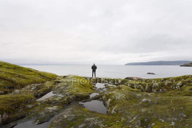 Man standing on rocks by Lake Vattern, Suécia — Fotografia de Stock