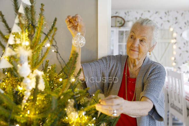 Senior femme décoration arbre de Noël — Photo de stock