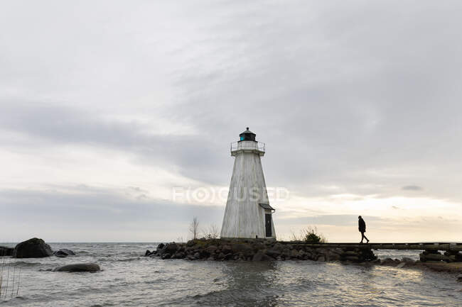 Woman walking by lighthouse at Lake Vattern, Sweden — Stock Photo