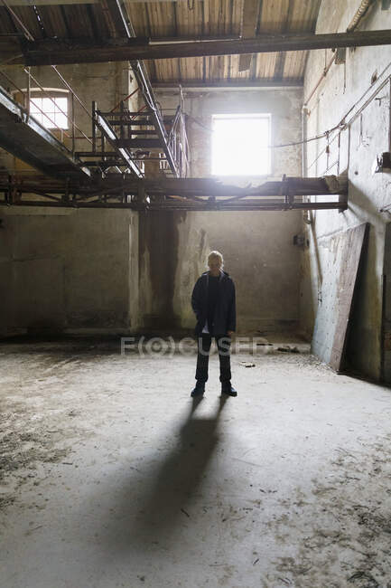 Mujer de pie en un edificio abandonado - foto de stock