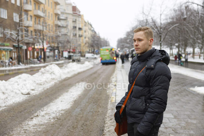 Jovem na estrada nevada na cidade no Condado de Estocolmo, Suécia — Fotografia de Stock