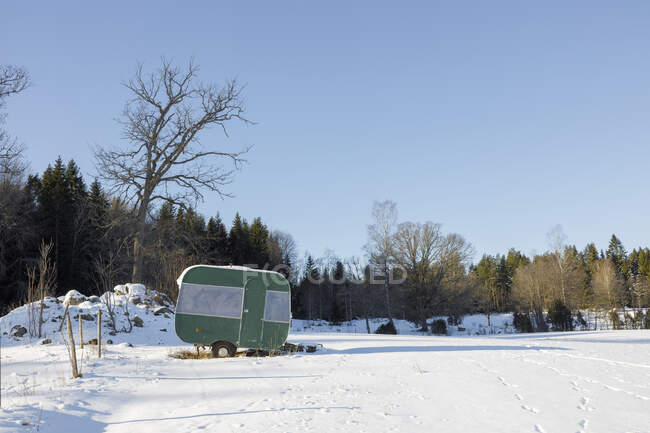 Camper trailer in snowy field — Fotografia de Stock