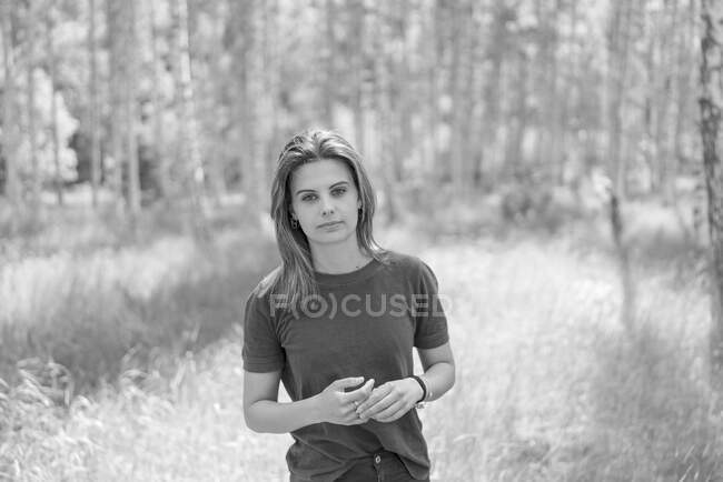 Jovem mulher no campo pela floresta — Fotografia de Stock