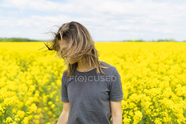 Молода жінка в полі жовтих квітів. — стокове фото