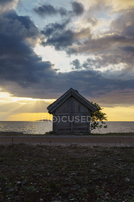 Cabaña junto al mar al atardecer - foto de stock