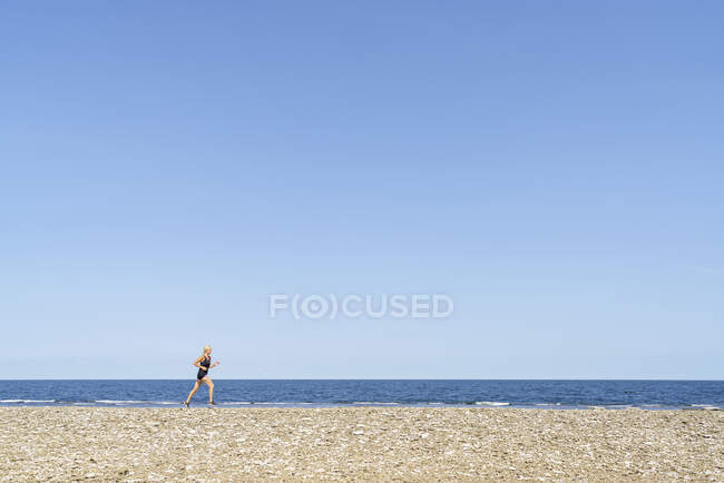 Жінка біжить на пляжі. — стокове фото