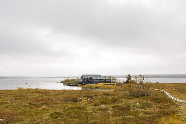 Boathouse on lake under clouds — Stock Photo