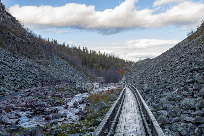 Boardwalk and mountain under clouds — Stockfoto