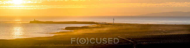 Lighthouse and coastline at sunset — Stockfoto
