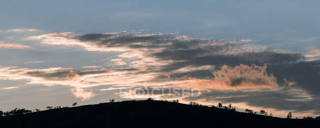 Nuvens e colina ao pôr-do-sol — Fotografia de Stock