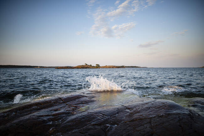 Хвиля спалахує на скелі на морі — стокове фото