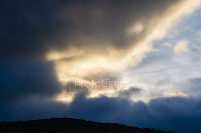 Облака и холм на закате — стоковое фото
