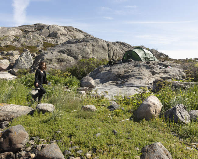 Senderismo de mujeres sobre rocas en Mollosund, Suecia - foto de stock