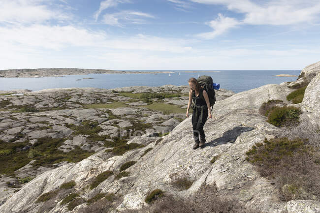Senderismo de mujeres sobre rocas en Mollosund, Suecia - foto de stock