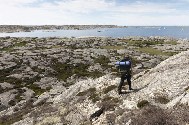 Femme randonnée sur les rochers à Mollosund, Suède — Photo de stock