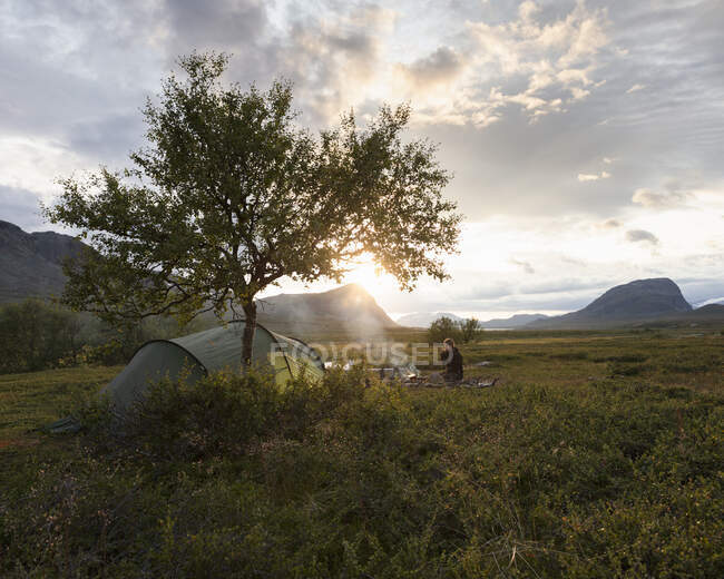 Jeune femme camping par Rasek montagne au coucher du soleil — Photo de stock
