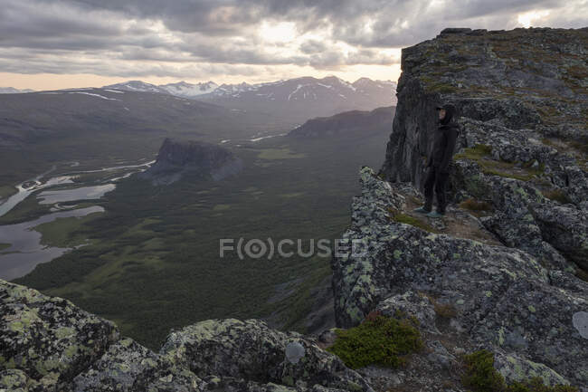 Жінка стоїть на скелі над долиною Рапа в національному парку Сарек (Швеція). — стокове фото