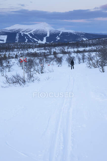 Esquiador en la montaña al atardecer - foto de stock
