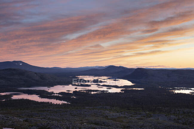 Силуэт гор у озера на закате — стоковое фото