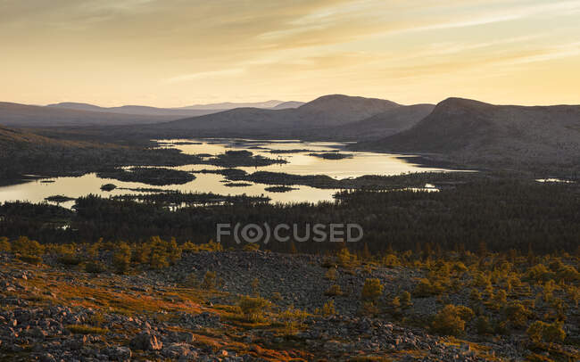 Silhouette of mountains by lake at sunrise — Stock Photo