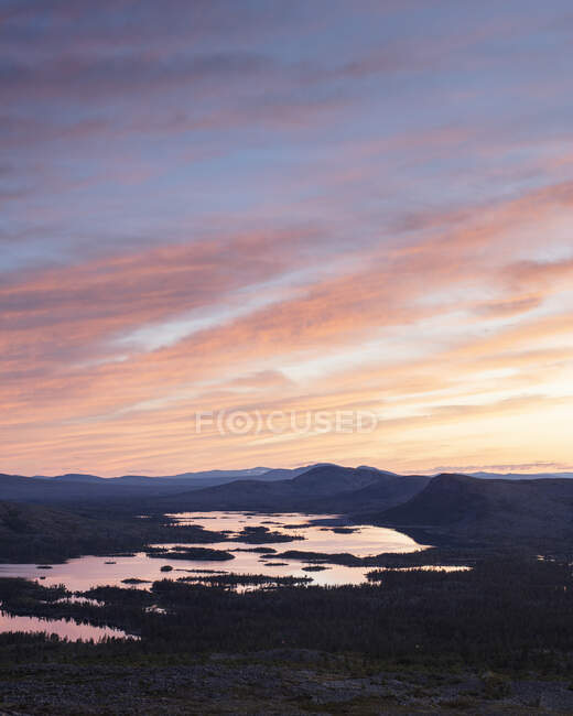 Silhouette delle montagne in riva al lago al tramonto — Foto stock