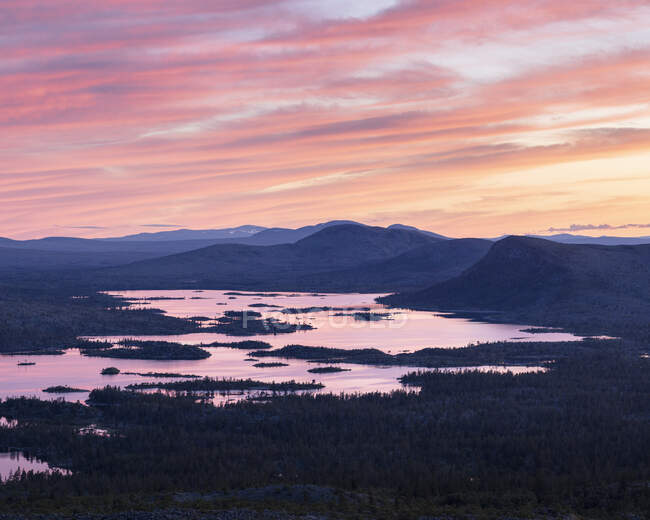 Силует гір біля озера на заході сонця — стокове фото