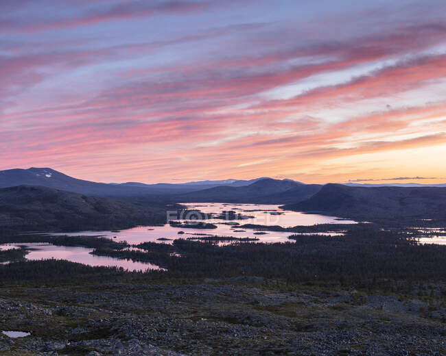 Silhouette de montagnes au bord du lac au coucher du soleil — Photo de stock