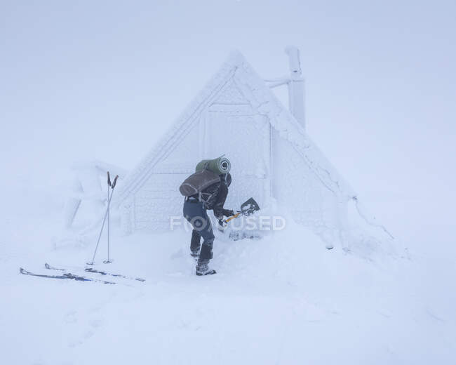 Jovem mulher por cabine nevada — Fotografia de Stock