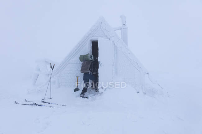 Mujer joven por la cabaña nevada - foto de stock