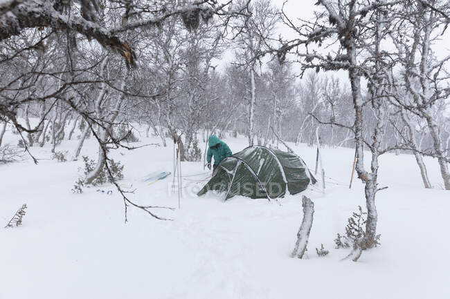 Mulher acampar na floresta nevada — Fotografia de Stock