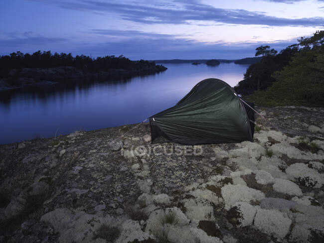 Tente près de la rivière au coucher du soleil — Photo de stock