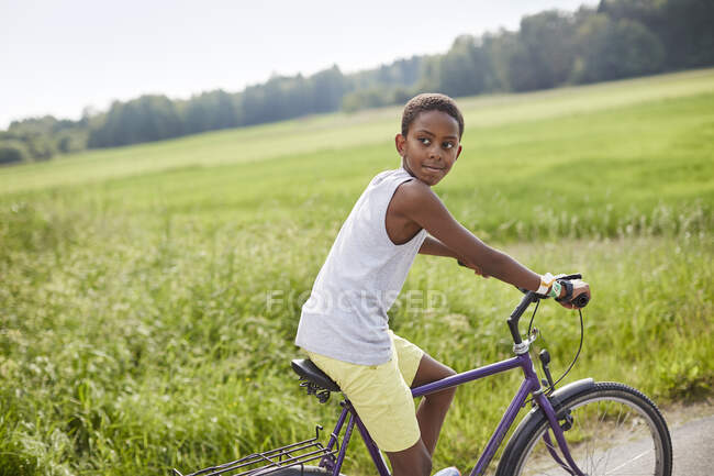 Мальчик на велосипеде по дороге — стоковое фото