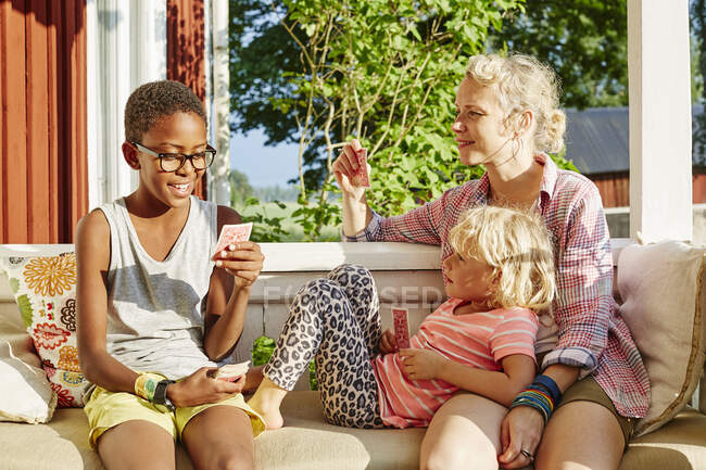 Familie spielt Karten auf Balkon — Stockfoto