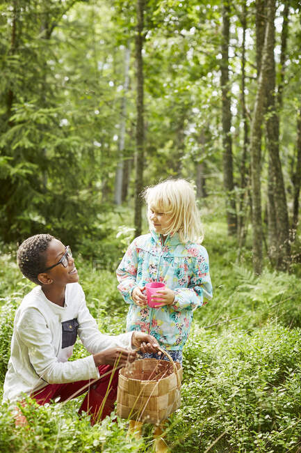 Siblings with basket in forest - foto de stock
