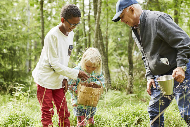 Man with his grandchildren in forest — Stock Photo