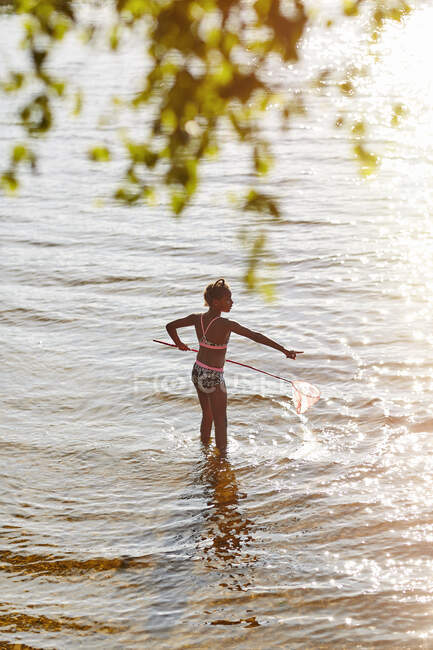 Menina brincando com rede no lago — Fotografia de Stock
