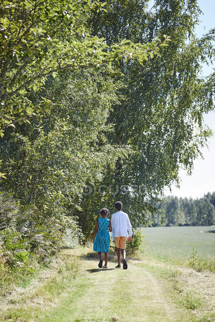 Siblings walking on path in forest — Fotografia de Stock