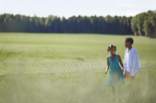 Siblings in field in summer — Photo de stock