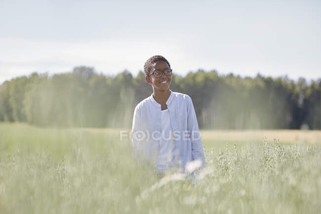 Усміхнений хлопчик у полі — стокове фото