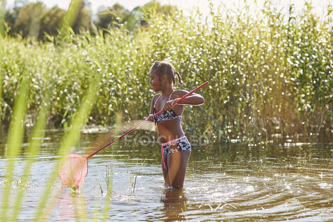 Girl playing with net in lake — Fotografia de Stock