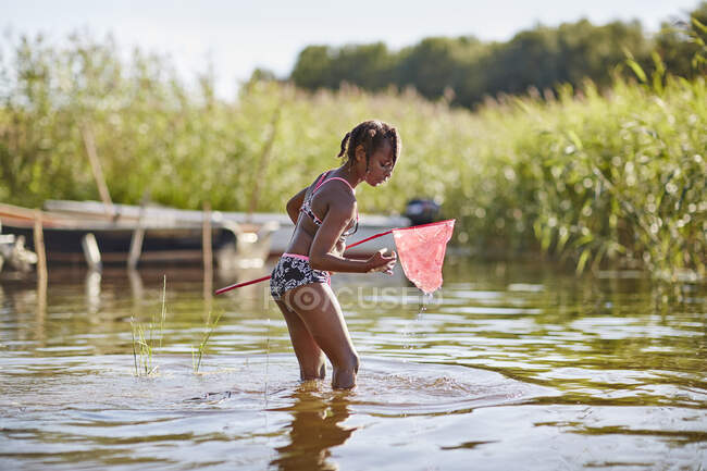 Girl playing with net in lake — Fotografia de Stock