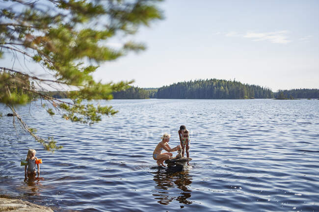 Família jogando no lago — Fotografia de Stock
