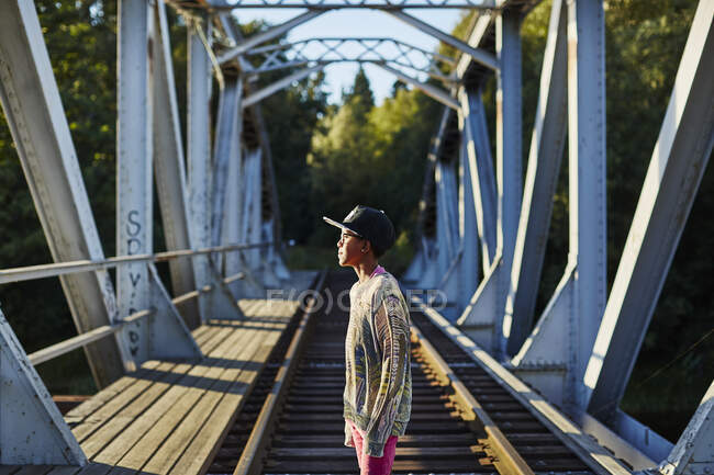 Boy in baseball cap on bridge - foto de stock